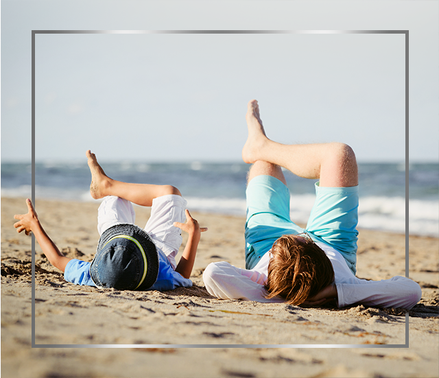Mother and child lying on beach with crossed legs, happy after Canespro fungal nail treatment
