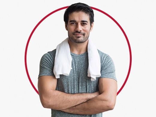 Muscular man with white towel around neck happy after Canesten sweat rash treatment
